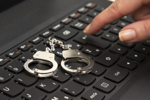 Handcuffs on a keyboard to represent internet sex crimes.