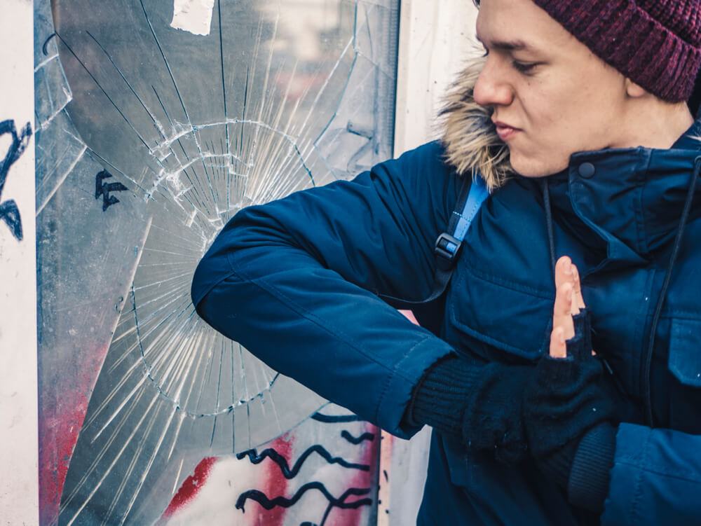 Young boy breaking windows.
