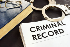 Criminal record file and handcuff in the table