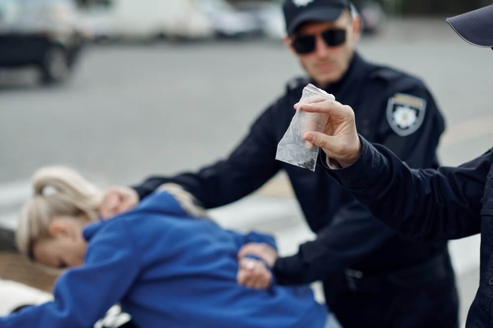 Lady arrested by the police for illegal drug possession.